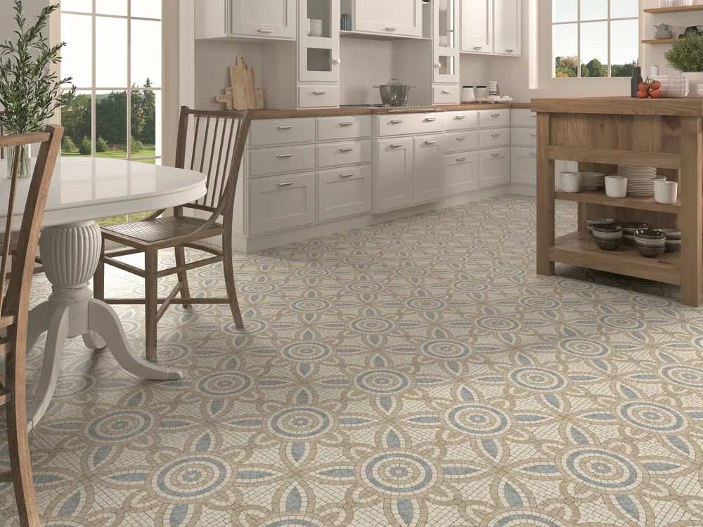 Kitchen interior with white cabinetry and timber accents showcasing Mikron Malta patterned floor tiles in soft beige and blue tones.